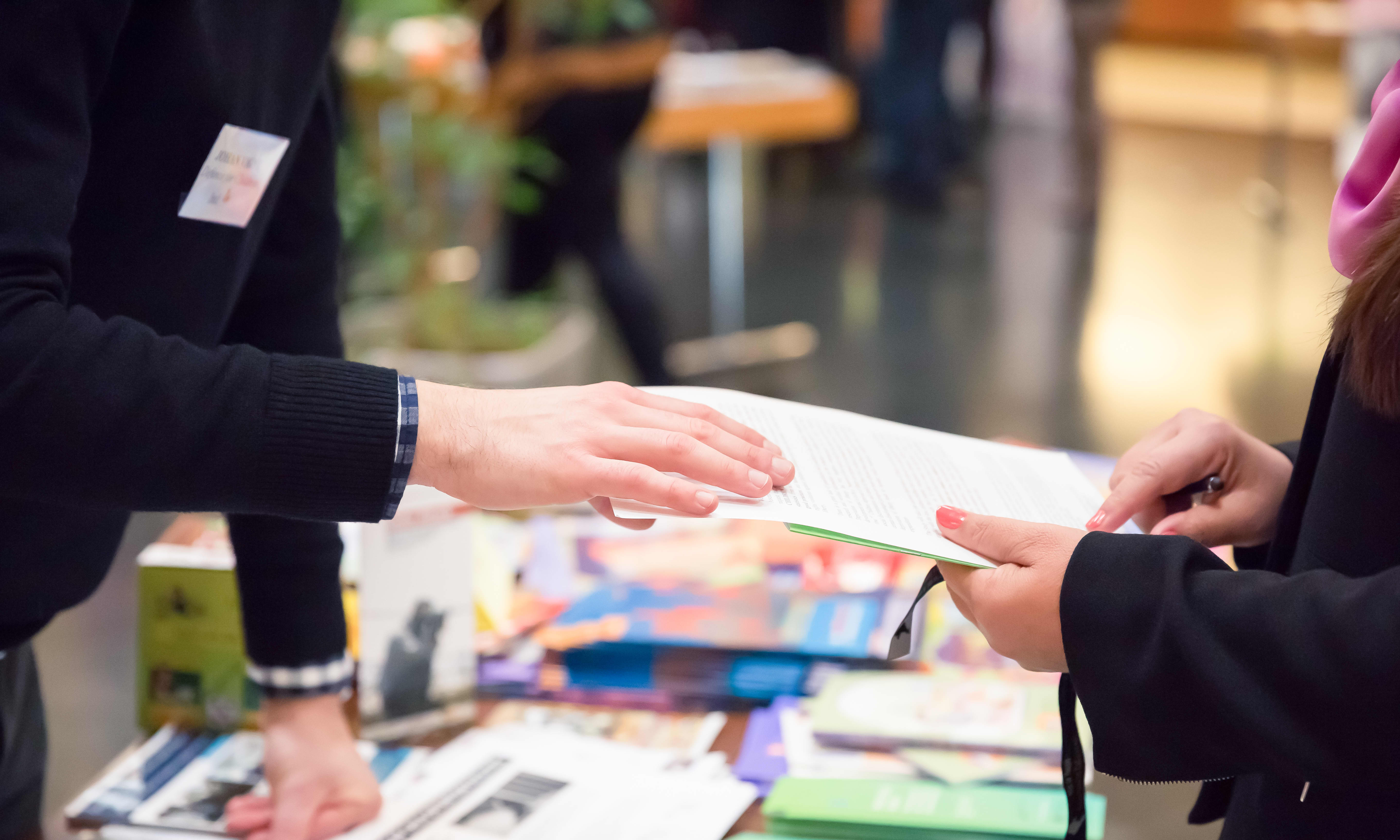 Nahaufnahme zweier Personen an einem Stand auf einer Messe