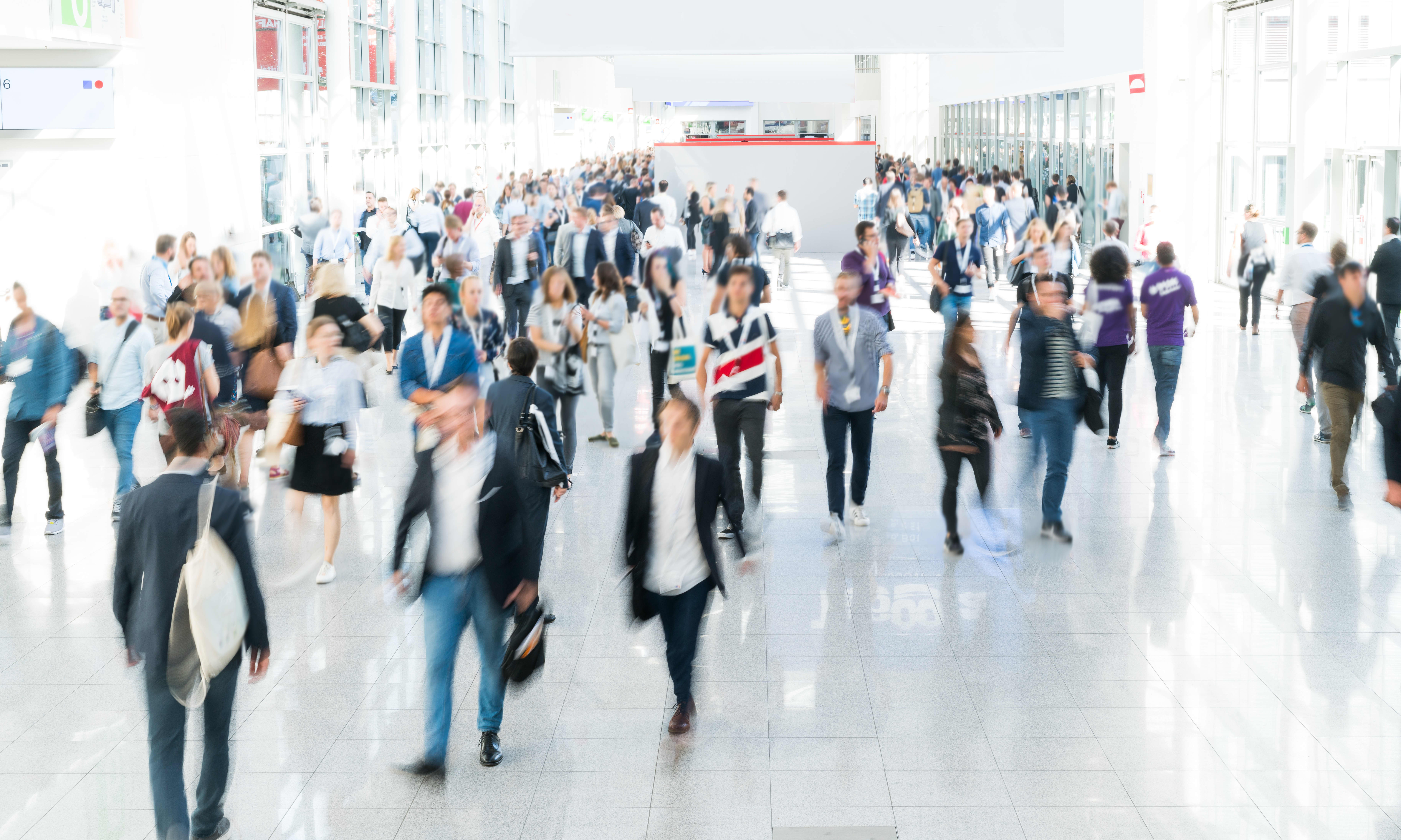 Verschwommene Menschen in einer Veranstaltungshalle auf einer Messe