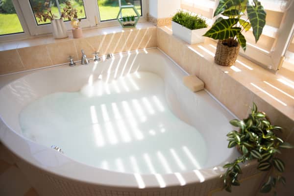 Helle Eckbadewanne mit Pflanzen und Tageslicht