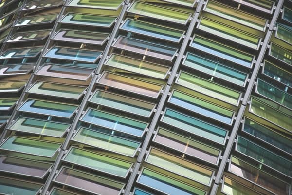 Moderne Glasfassade mit geöffneten Lamellenfenstern in verschiedenen Farben