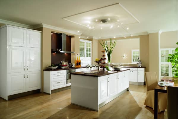 Moderne Landhausküche mit weißer Einrichtung und Holzdetails von Aroundhome. Die Küche ist durch warmes Licht und naturale Farben geprägt.