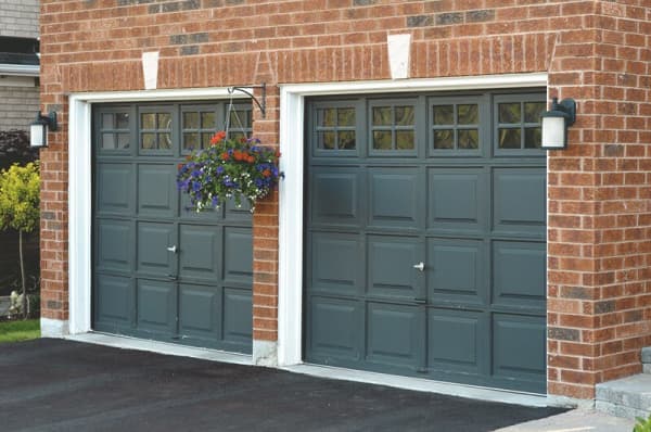 Zwei Garagentore einer Massivgarage mit Fenstern und Tormuster