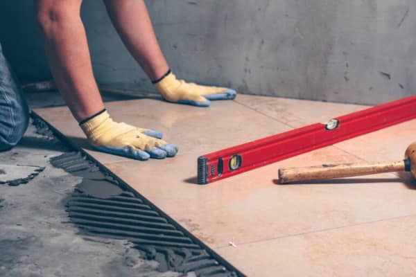 Fliesenleger legt Bodenfließen