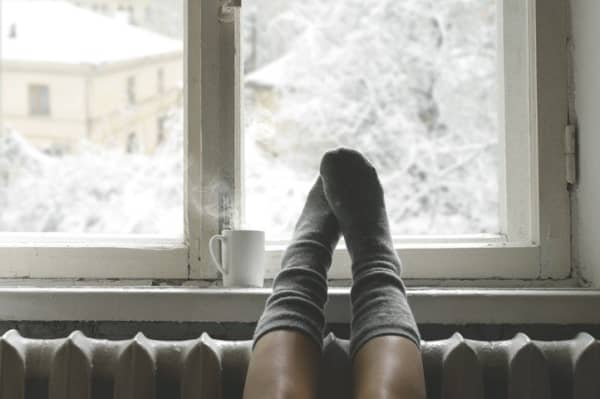 Gemütlicher Wintertag am Fenster mit Ausblick auf verschneite Landschaft