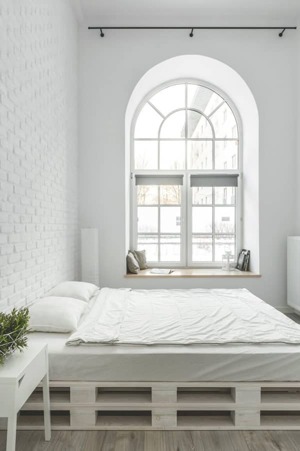 Helles Schlafzimmer mit großem Rundbogenfenster und Fensterbank