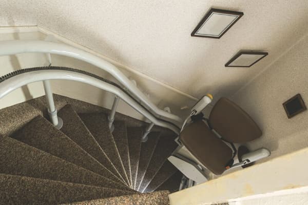 Treppenlift fährt eine schmale, gewundene Treppe hinauf