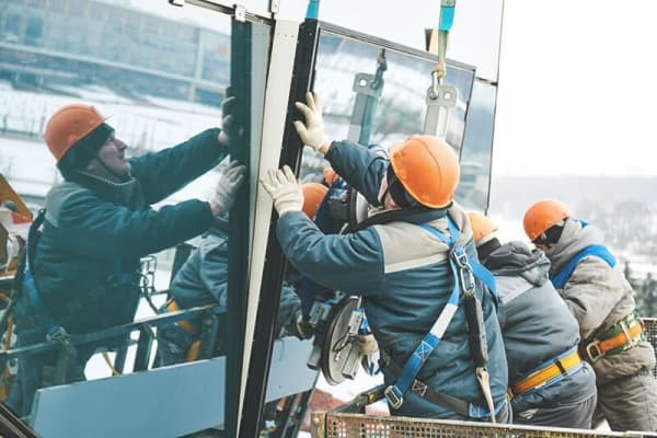 Fassadenbau: Monteure installieren große Glasfront nach einer Fensterreparatur