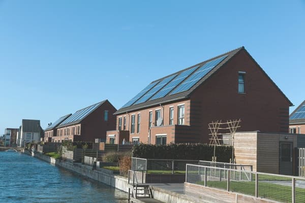 Solaranlage auf dem Dach eines Mehrfamilienhauses am Flussufer