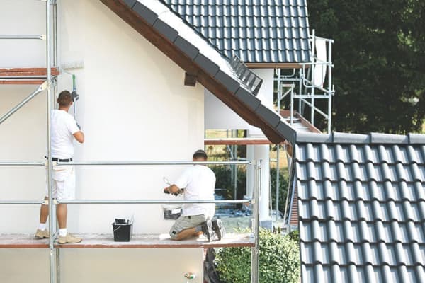 Maler streichen Fassade einer Hauswand