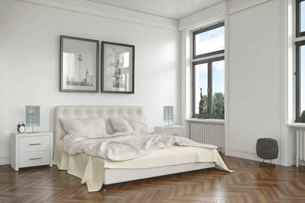 Helles Schlafzimmer mit Doppelbett, Parkettboden und großen Schallschutzfenstern