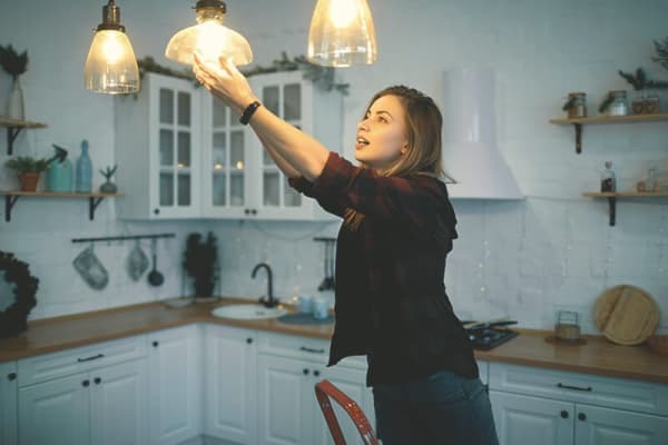 Frau tauscht Glühbirnen aus