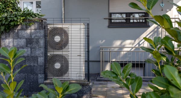 Wärmepumpe vor einem modernen Haus