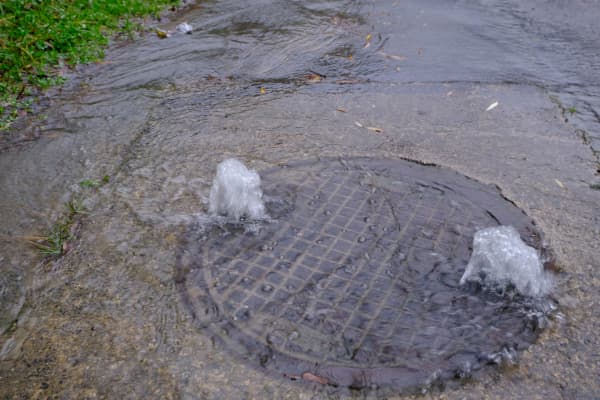 Überlaufendes Abwassersystem verursacht Überschwemmung auf einer Straße