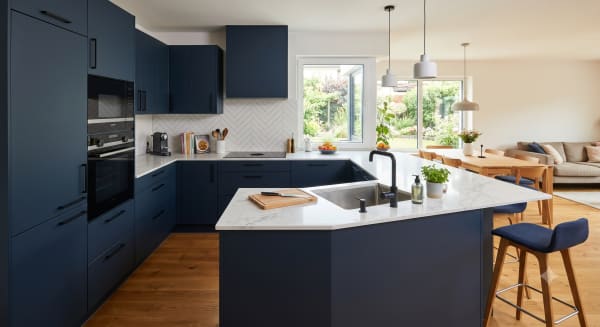 Moderne blaue G-Küche mit Kochinsel und offenem Essbereich
