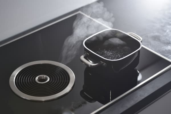 Topf auf einem Induktionskochfeld mit integriertem Dunstabzug