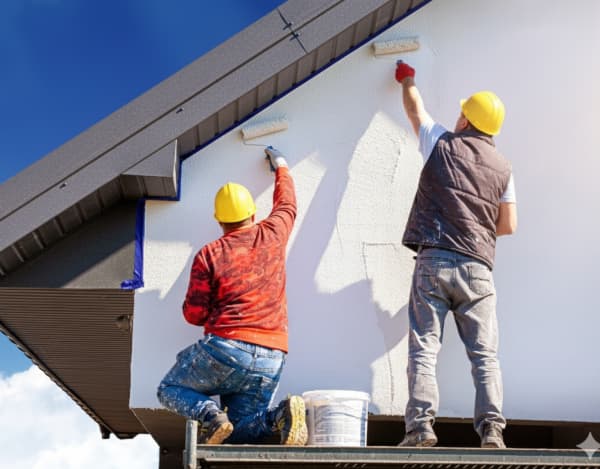 Bild von zufriedenen Hauseigentümern und Handwerkern, die sich die Hände schütteln.