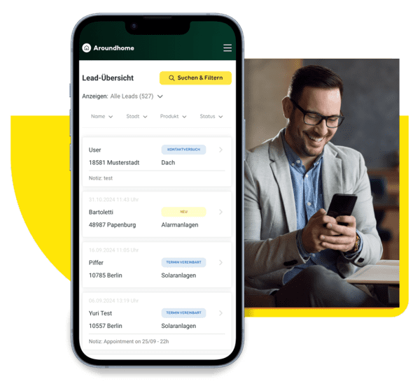Im Vordergrund steht ein Mobiltelefon mit dem Partner Cockpit von Aroundhome, im Hintergrund bedient eine freundliche Handwerkerin das Cockpit auf dem Handy.