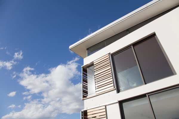 Modernes Haus mit großen Fenstern und Fensterläden zum Schieben