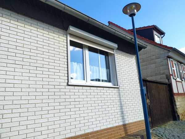 Vorbaurolladen vor einem Fenster eines Einfamilienhauses