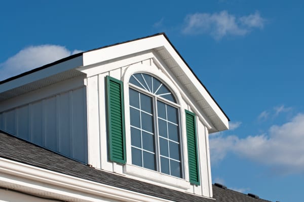 Ein Rundbogenfenster mit Sprossen in einem Dachgeschoss