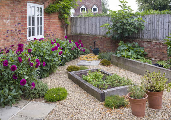 Kleiner Garten mit Kieselsteinen und Beet.