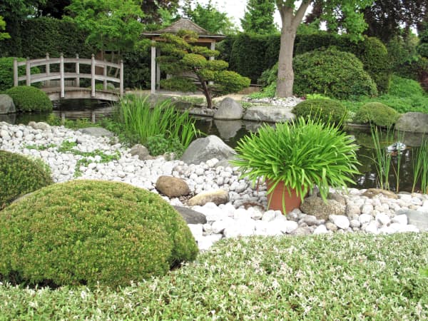 Steingarten mit einer Brücke und einem Teich.