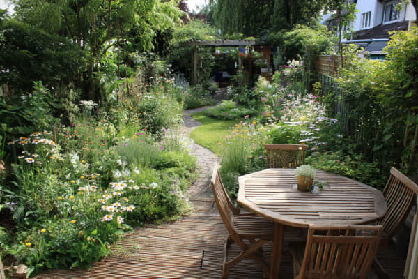 Garten naturnahe gestaltet mit Holzterasse.
