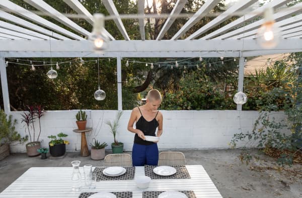 Frau unter offener Terrassenüberdachung auf Dachterrasse