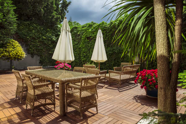 Terrasse mit Holzfliesen und Rattan-Möbeln
