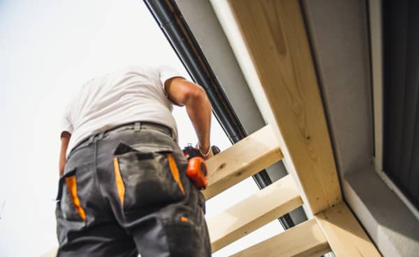 Eine Terrassenüberdachung aus Holz wird selbst gebaut mit Wandpfette und Sparren