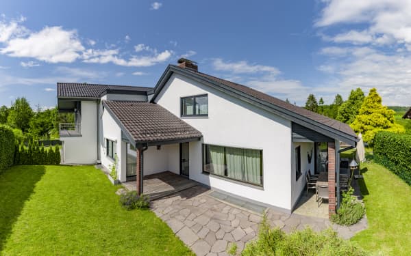 Wohnhaus mit verlängertem Hausdach als Terrassenüberdachung mit Ziegeln.