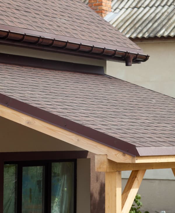 Terrassenüberdachung aus Holz mit Ziegeldach, angepasst an Optik des Hausdachs.