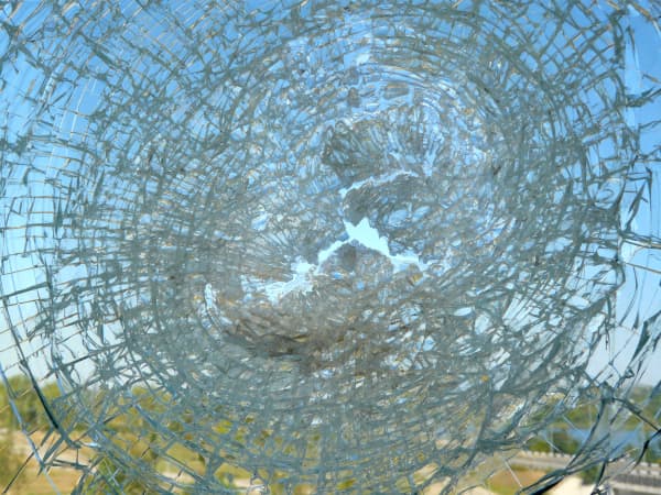 Gebrochenes VSG Sicherheitsglas mit Scherben, die an Folie haften bleiben.