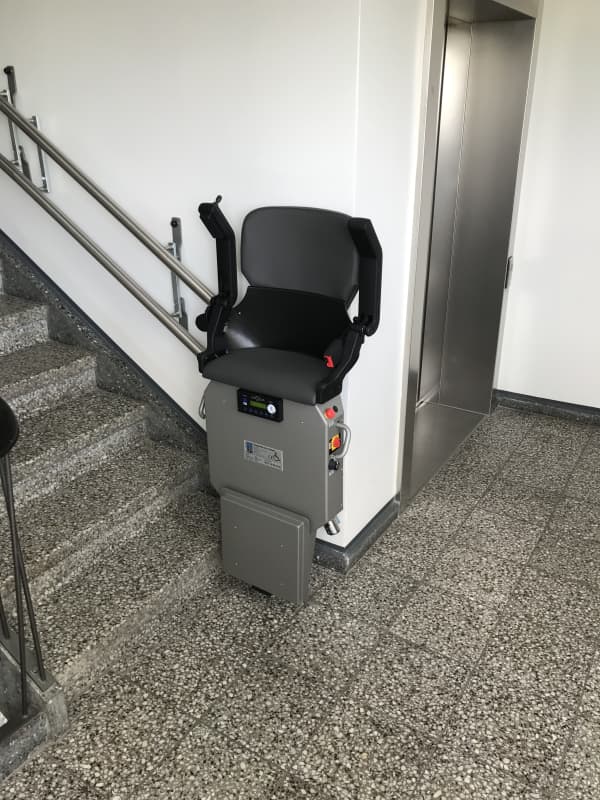 Treppenlift zum Stehen in einem Treppenhaus.