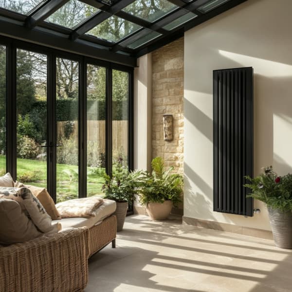 Wintergarten mit schwarzem Heizkörper an der Wand.