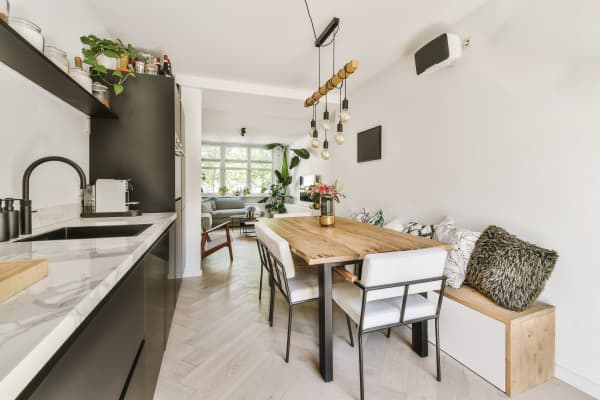 Offene Wohnküche mit Sitzecke und Esstisch aus Massivholz