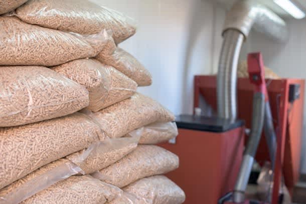 Holzpellets lagern mit Pelletheizung im Hintergrund