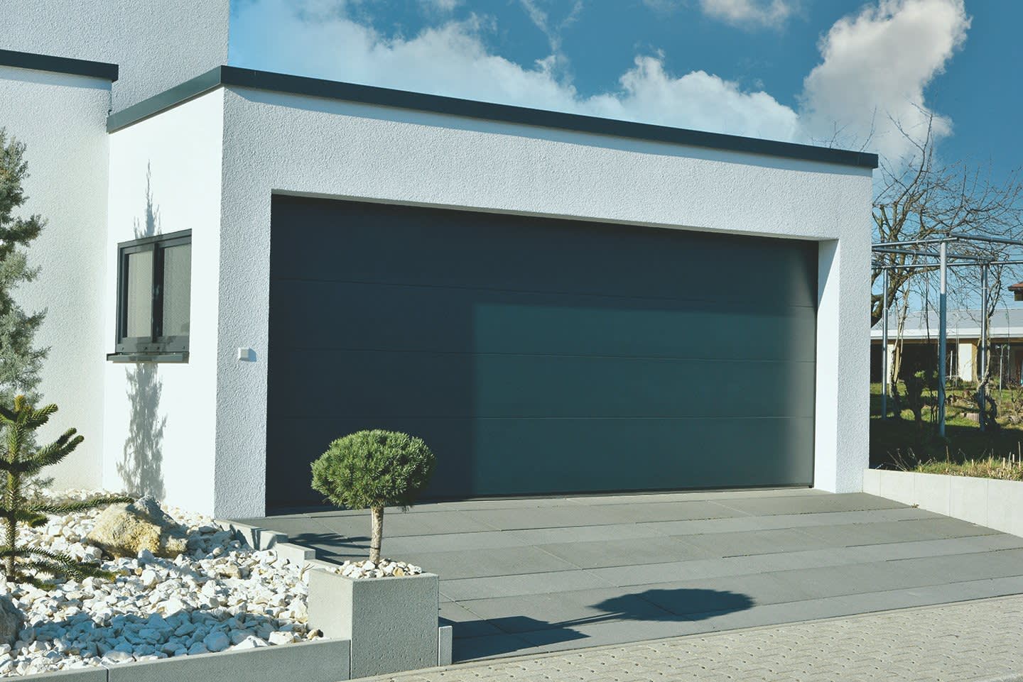 Garage mit breitem Garagentor und Fenster angebaut ans Wohnhaus