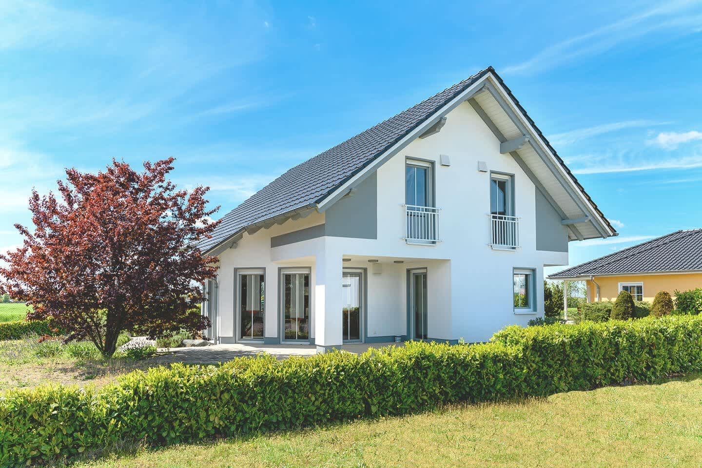 Modernes Einfamilienhaus mit weißer Fassade und Garten