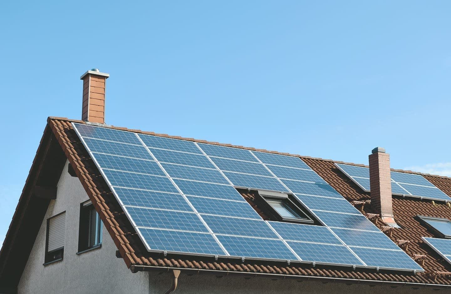 Einfamilienhaus mit großer Solaranlage auf dem Dach vor blauem Himmel