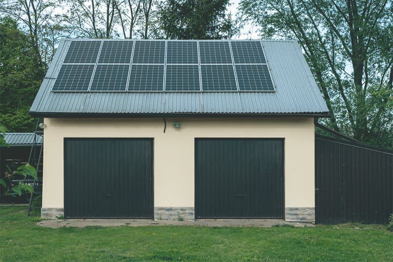 Solaranlage auf Blechdach einer gelb angestrichenen Doppelgarage