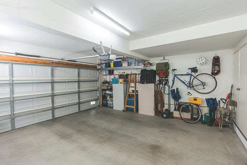 Innenraum einer Garage ohne Auto mit Fahrrad und Regal an der Wand