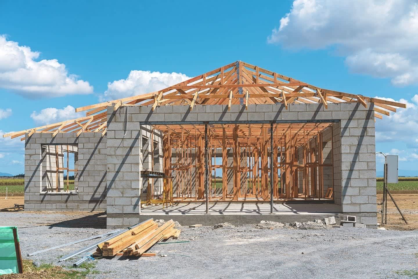 Garagenbau mit unfertigen Garagenwänden aus Stein und Holzpfosten als Dach