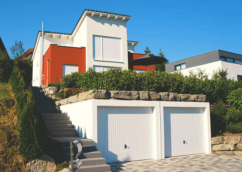 Betonfertiggarage in Hanglage mit Dachterrasse und Begrünung