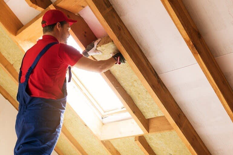 Handwerker bringt Dachdämmung an