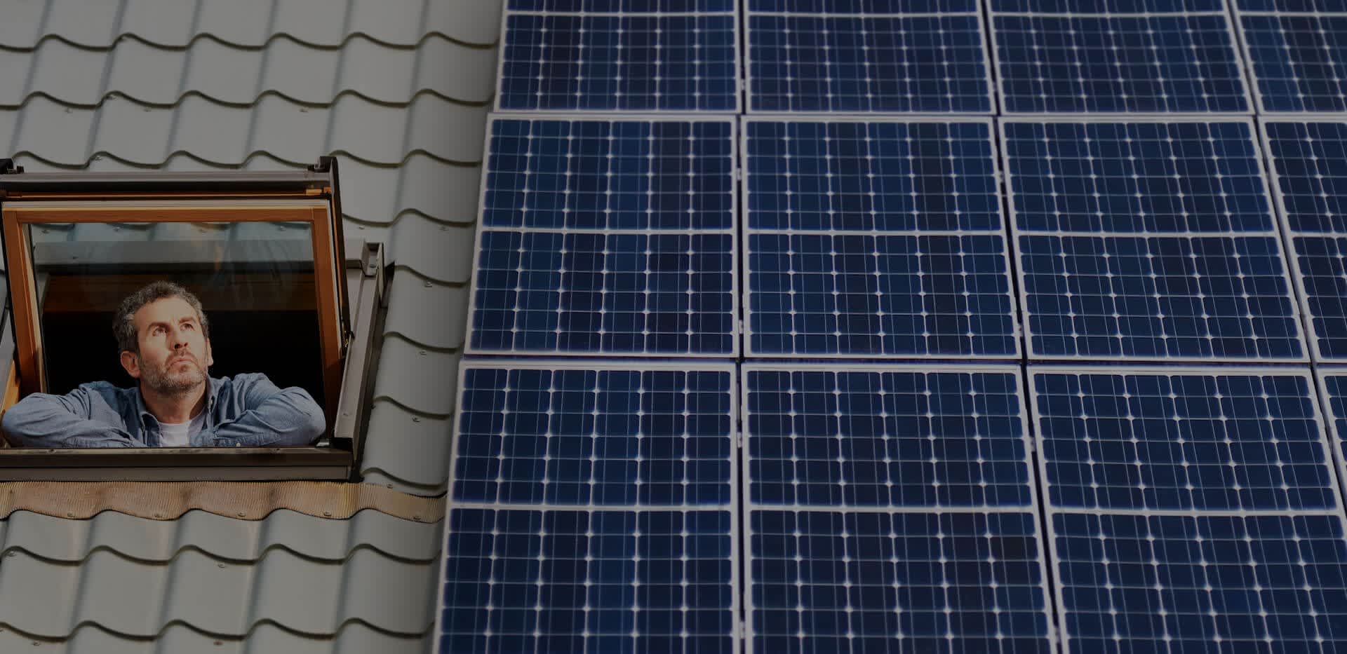 Hausdach mit großer Solaranlage, daneben ein Dachfenster aus dem eine Mann sieht