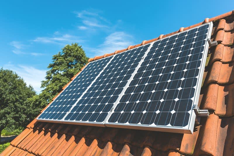 Solaranlage mit drei Solarmodulen auf einem Schrägdach mit roten Ziegeln