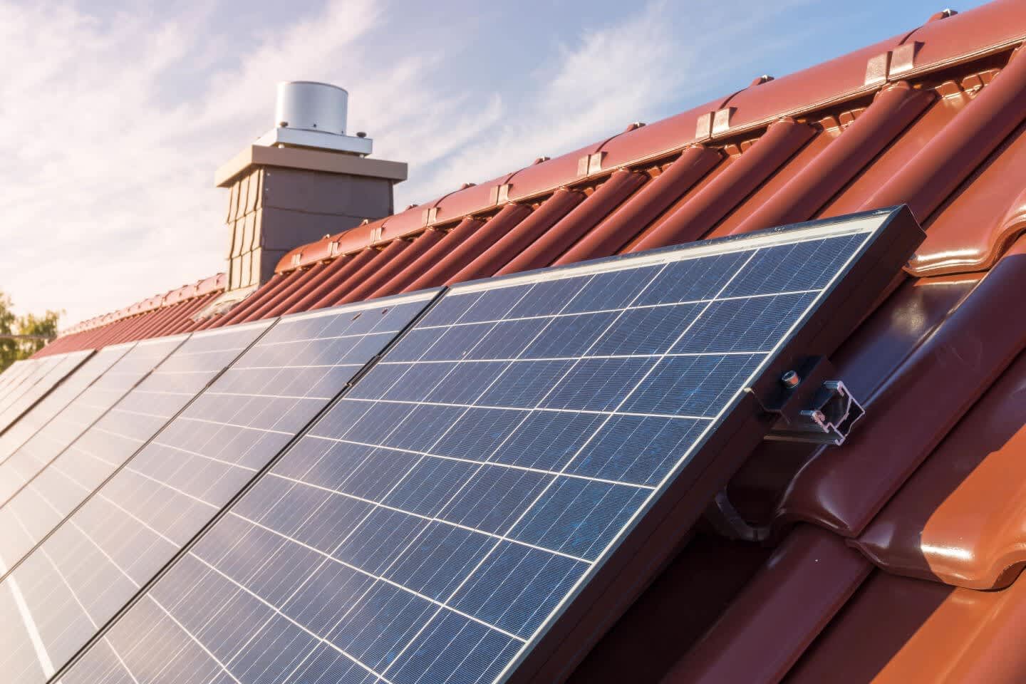 Photovoltaikmodule auf einem Schrägdach, das mit roten Ziegeln gedeckt ist