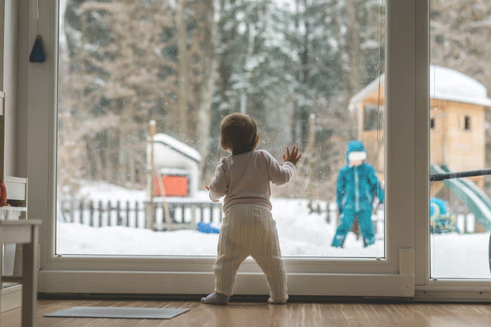 Baby steht an Fenster