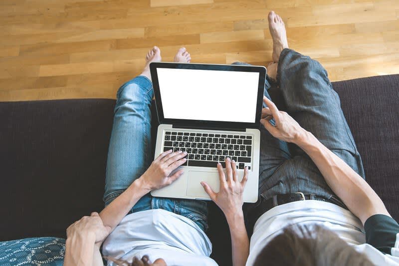 Paar mit Laptop auf Couch